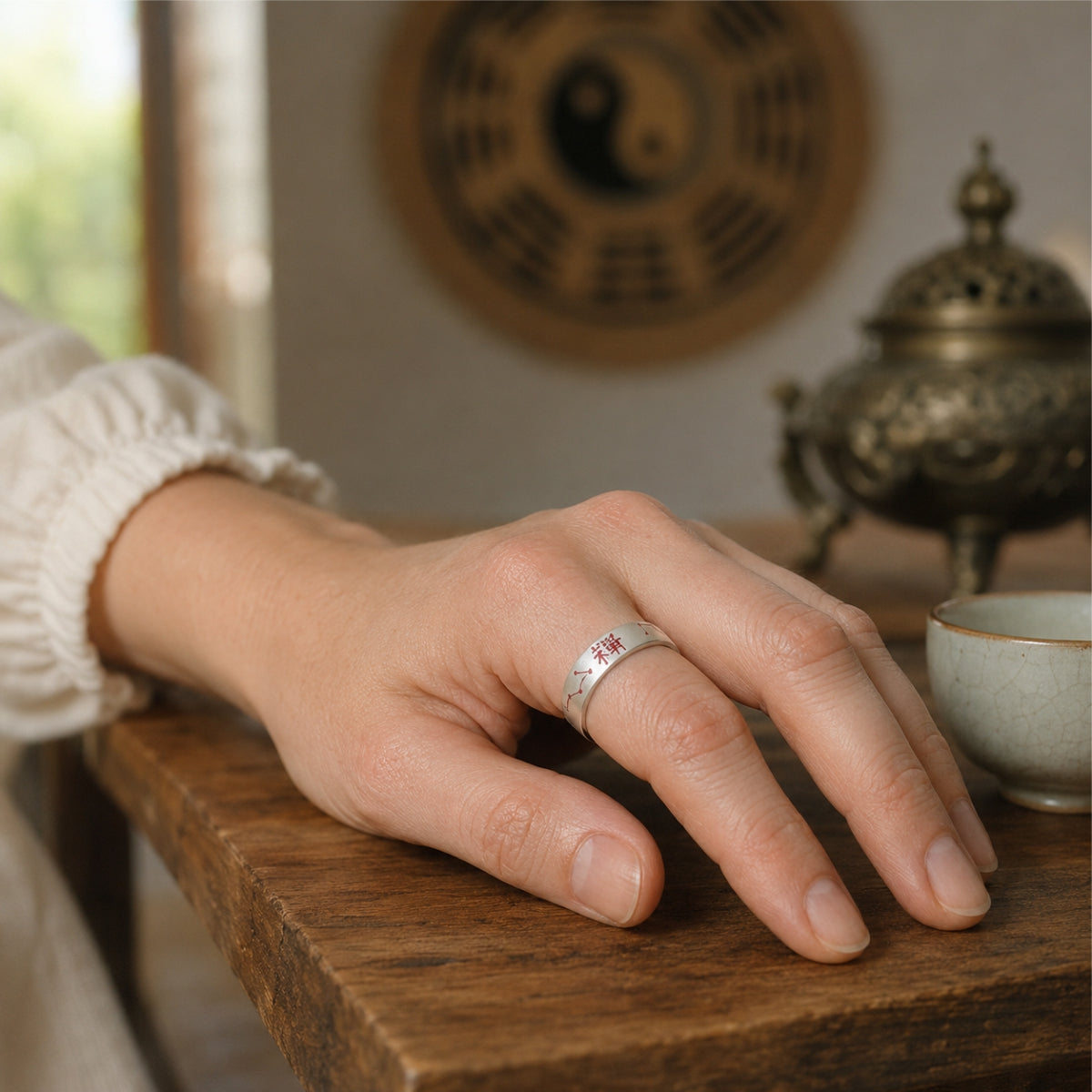 Woman wearing S925 silver BeiDou talisman fortune ring on finger, Taoist Bagua background