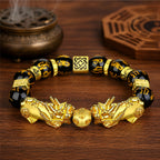 Double gold Pixiu wealth bracelet with black obsidian six-syllable mantra beads, infinity knot spacers, and fortune bead.