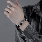 Black obsidian Pixiu wealth attraction bracelet with silver guardian details, worn on the wrist.