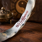 Close-up of the red cinnabar protection talisman engraved on a hand-forged 925 silver Taoist Mobius bracelet.