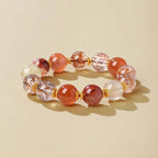 Good luck energy bracelet for women with red, gold and clear beads on a warm beige background