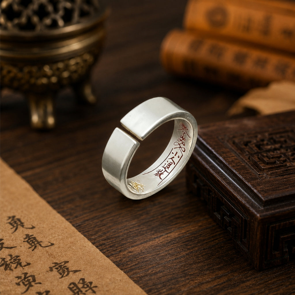 Close-up of a Taoist inner-engraved protection ring with hand-painted cinnabar talisman details and a polished sterling silver band