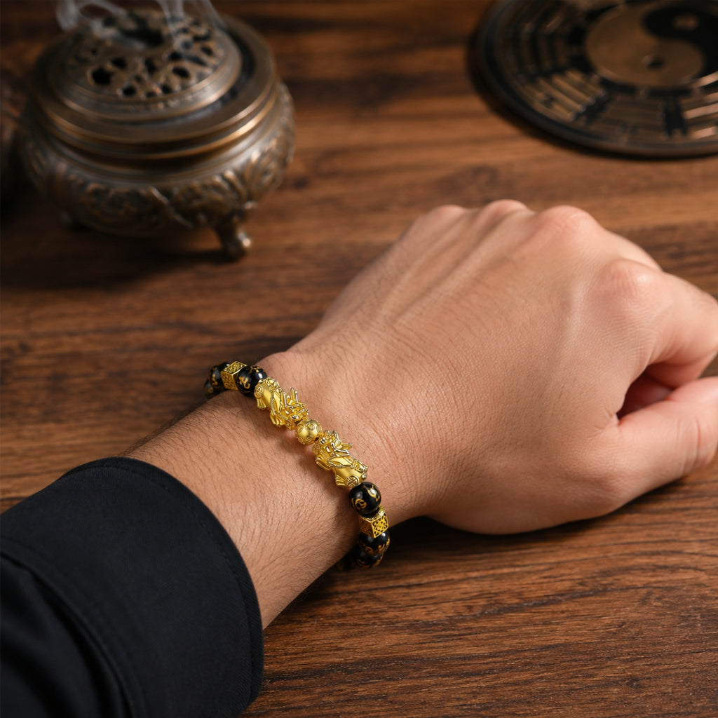 Male wrist wearing a double Pixiu wealth attraction and retention bracelet with black obsidian beads.