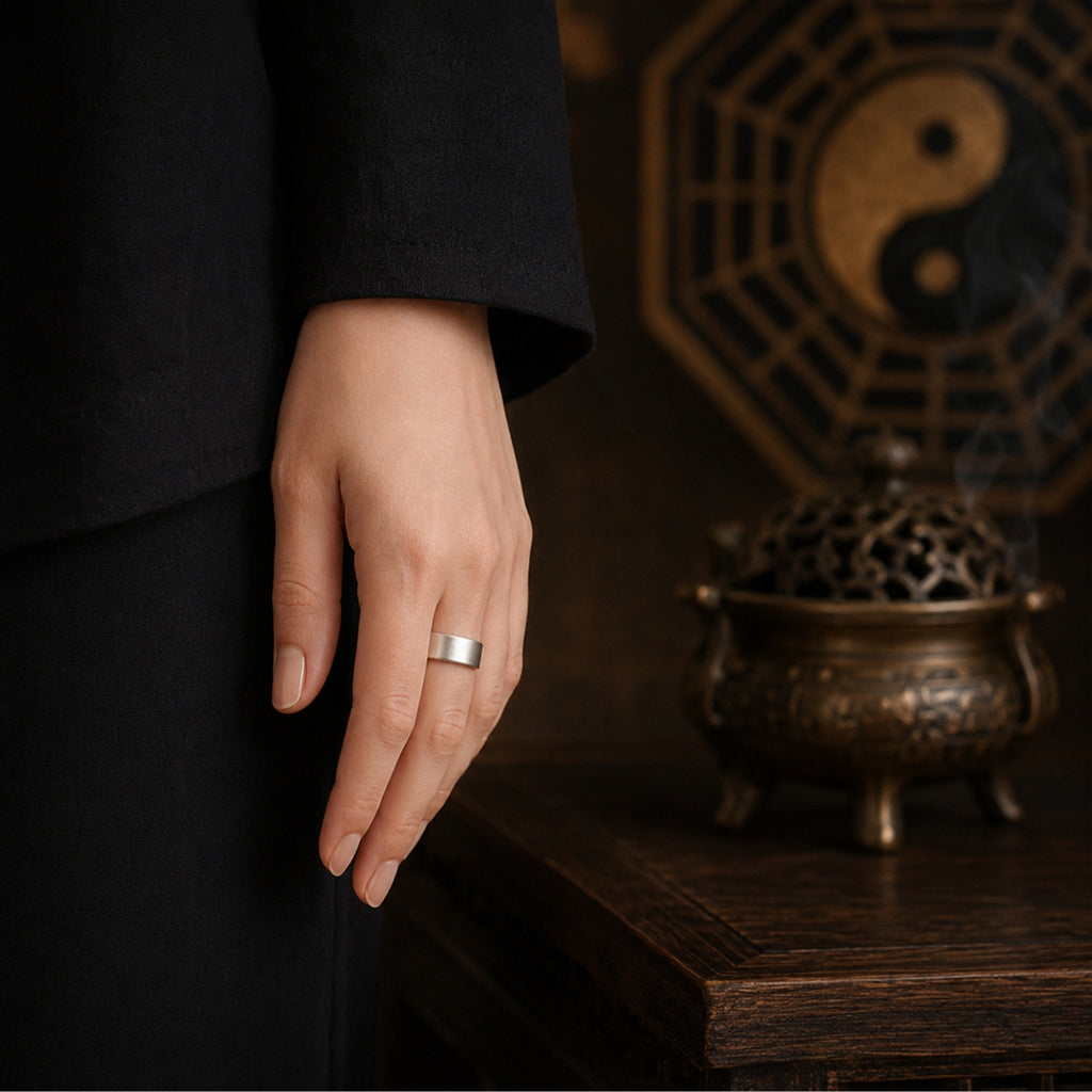 Male hand wearing a minimalist 925 silver Taoist four-talisman protection ring in a Daoist incense and Bagua setting