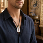 Male model wearing a hand-hammered Taoist dual-sided protection talisman necklace with cinnabar talisman details