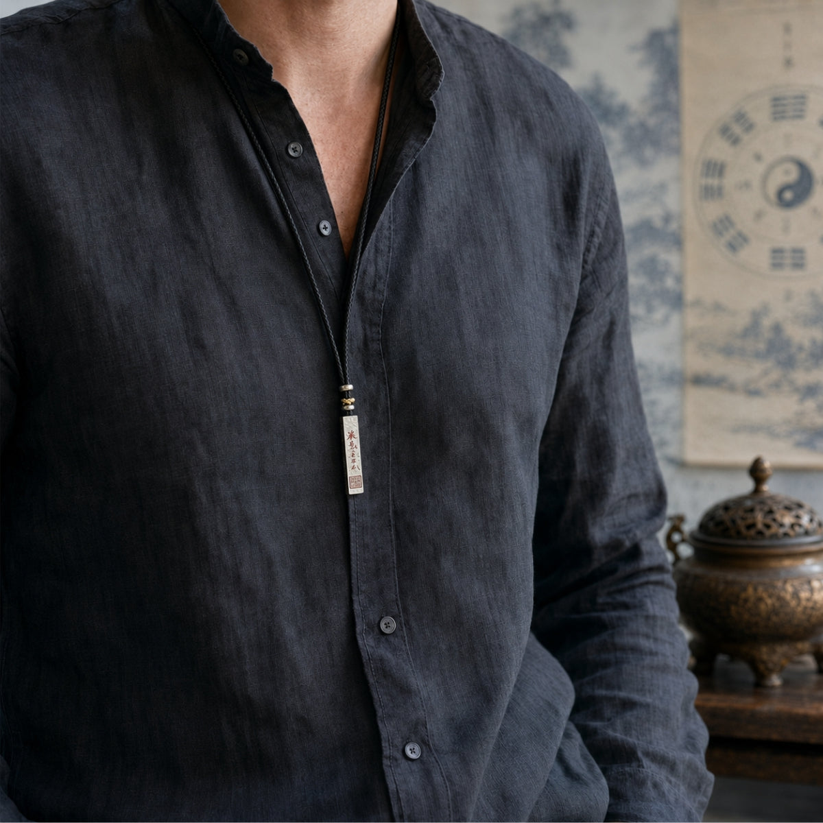 Male model wearing a Taoist supreme protection and fortune talisman necklace with a 925 silver cinnabar pendant.