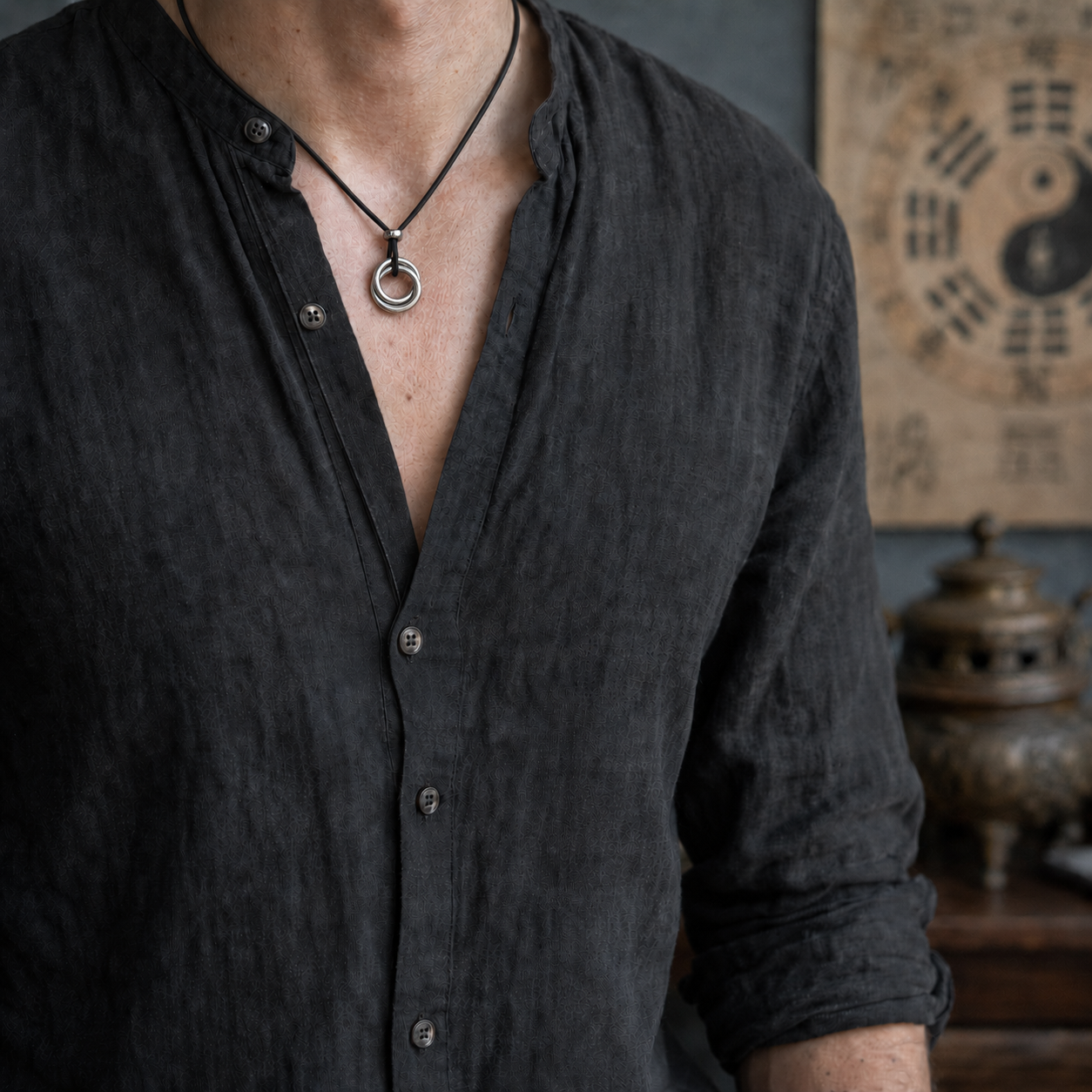 Male model wearing a handcrafted Taoist Yin Yang balance pendant with a sterling silver Qiankun circle design.