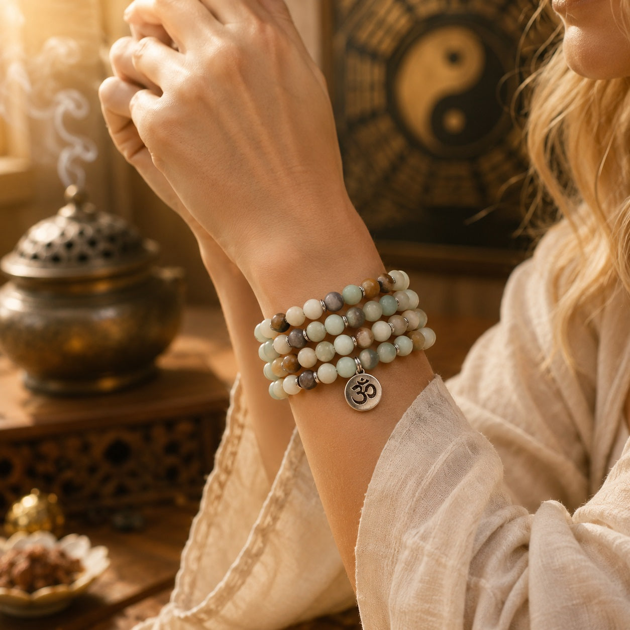 Woman wearing multi-color Amazonite 108 mala beads as a multi-wrap bracelet with an Om pendant