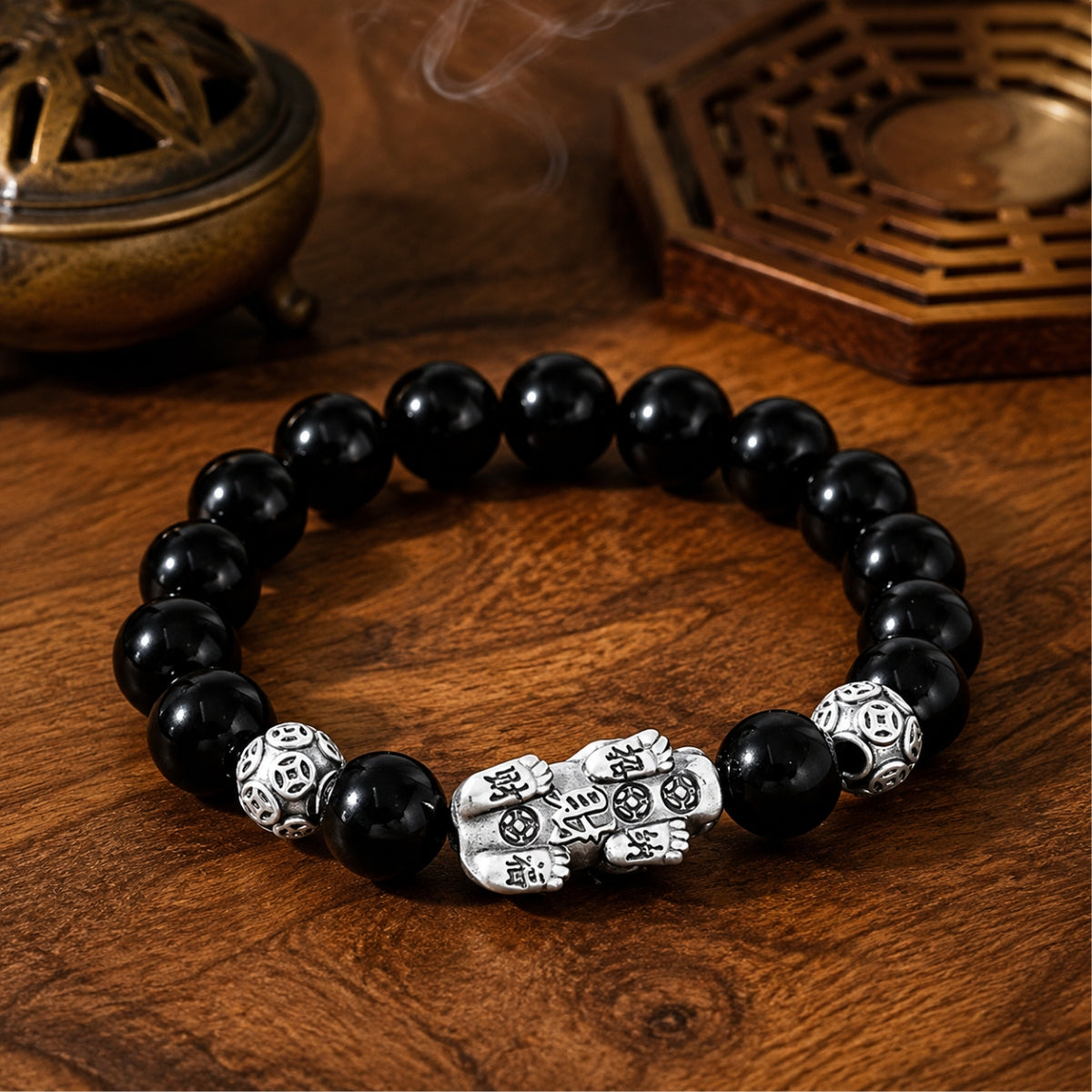 Reverse view of a black obsidian Pixiu wealth guardian bracelet showing detailed silver Pixiu engraving.