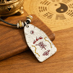 Reverse side of a hand-hammered Taoist protection talisman showing cinnabar evil-warding symbols and a Yin-Yang detail