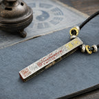 Reverse view of a silver Taoist protection and fortune talisman pendant showing hand-painted cinnabar inscriptions and gold-tone details.
