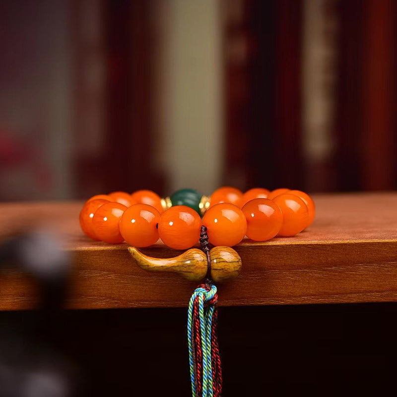 Side view of a South Red Agate Taoist wealth bracelet with a wealth-gathering gourd and multicolor tassel