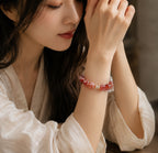 Woman wearing red hematoid quartz crystal energy healing bracelet with gold accent beads Taoist KaiGuang love attraction confidence spiritual jewelry