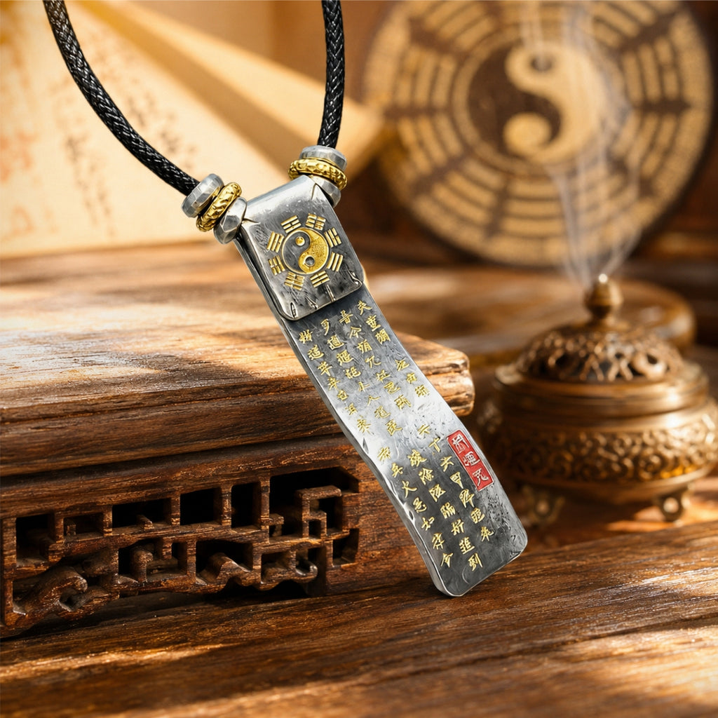 Reverse side of a silver Taoist protection and fortune talisman pendant with Bagua detail, engraved fortune inscription, and cinnabar seal.