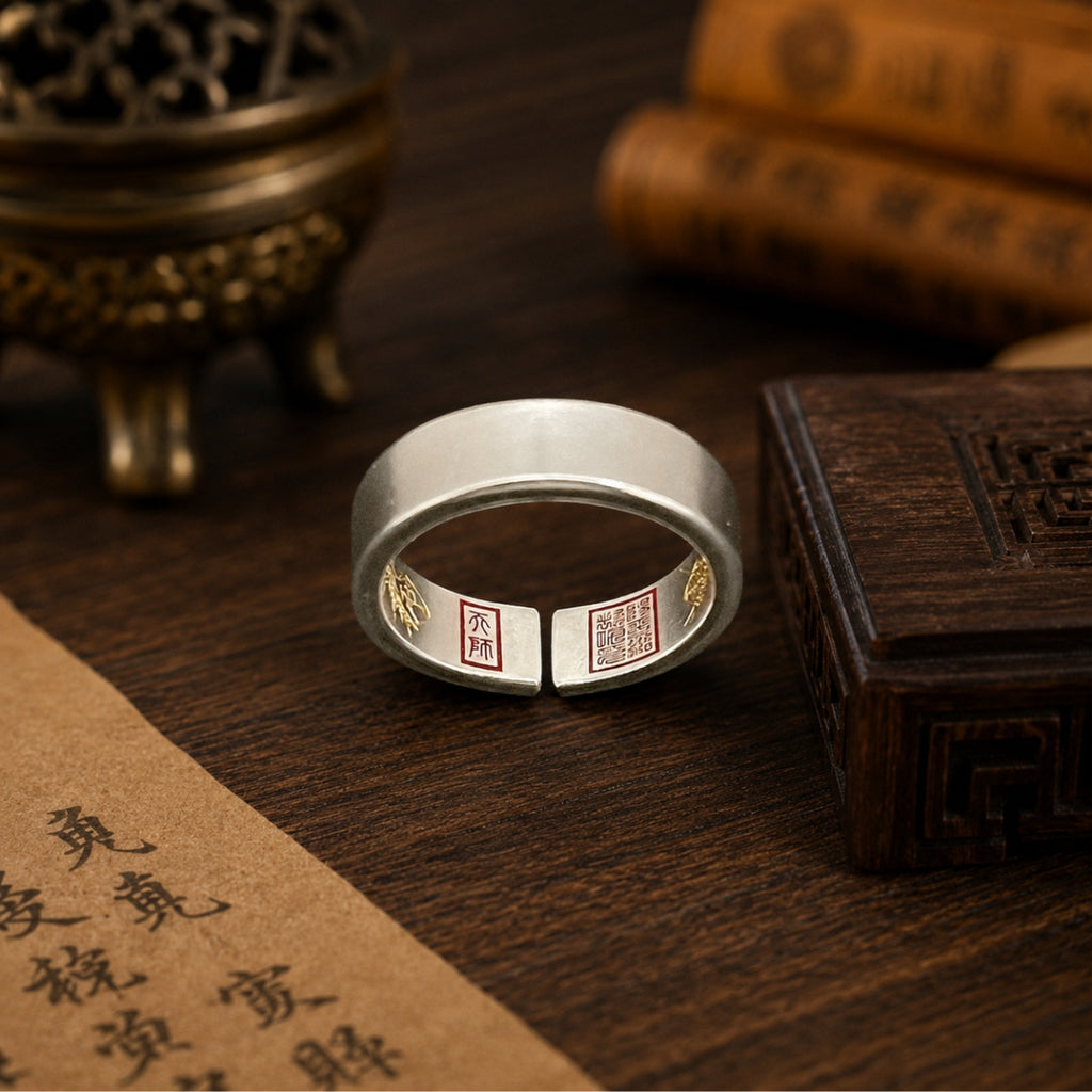Handcrafted 925 sterling silver Taoist four-talisman protection ring showing cinnabar-painted inner talismans on a Daoist altar table