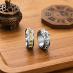 Two Taoist protection spinner rings with raised talisman-style engravings and rotating outer bands.