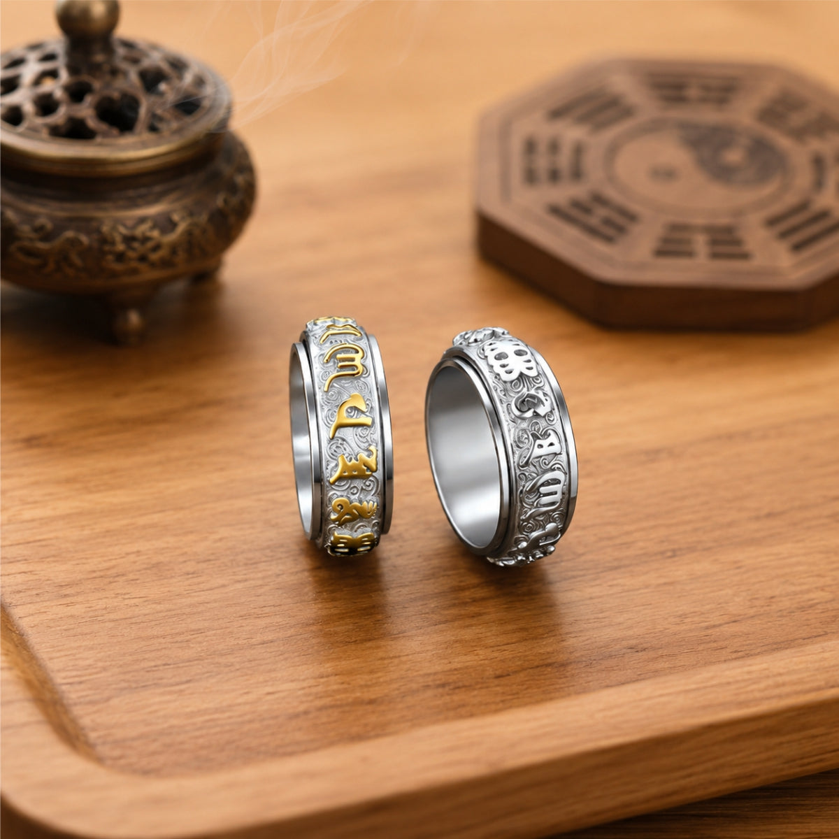 Two Taoist protection spinner rings with raised talisman-style engravings and rotating outer bands.