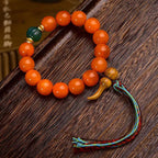 South Red Agate wealth attraction bracelet for women with a green jade accent bead, Taoist gourd pendant, and five-element tassel