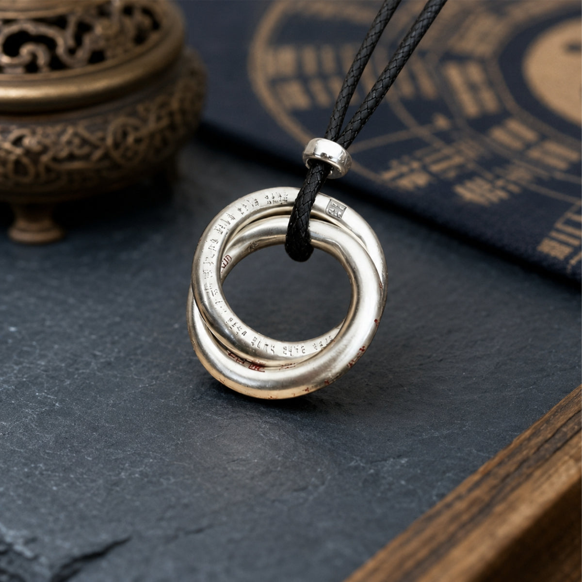 Sterling silver Taoist Yin Yang balance pendant showing its circular engraved design and black cord.