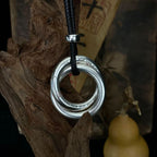 Detailed view of a sterling silver Taoist Yin Yang balance circle pendant with engraved symbols and black cord.