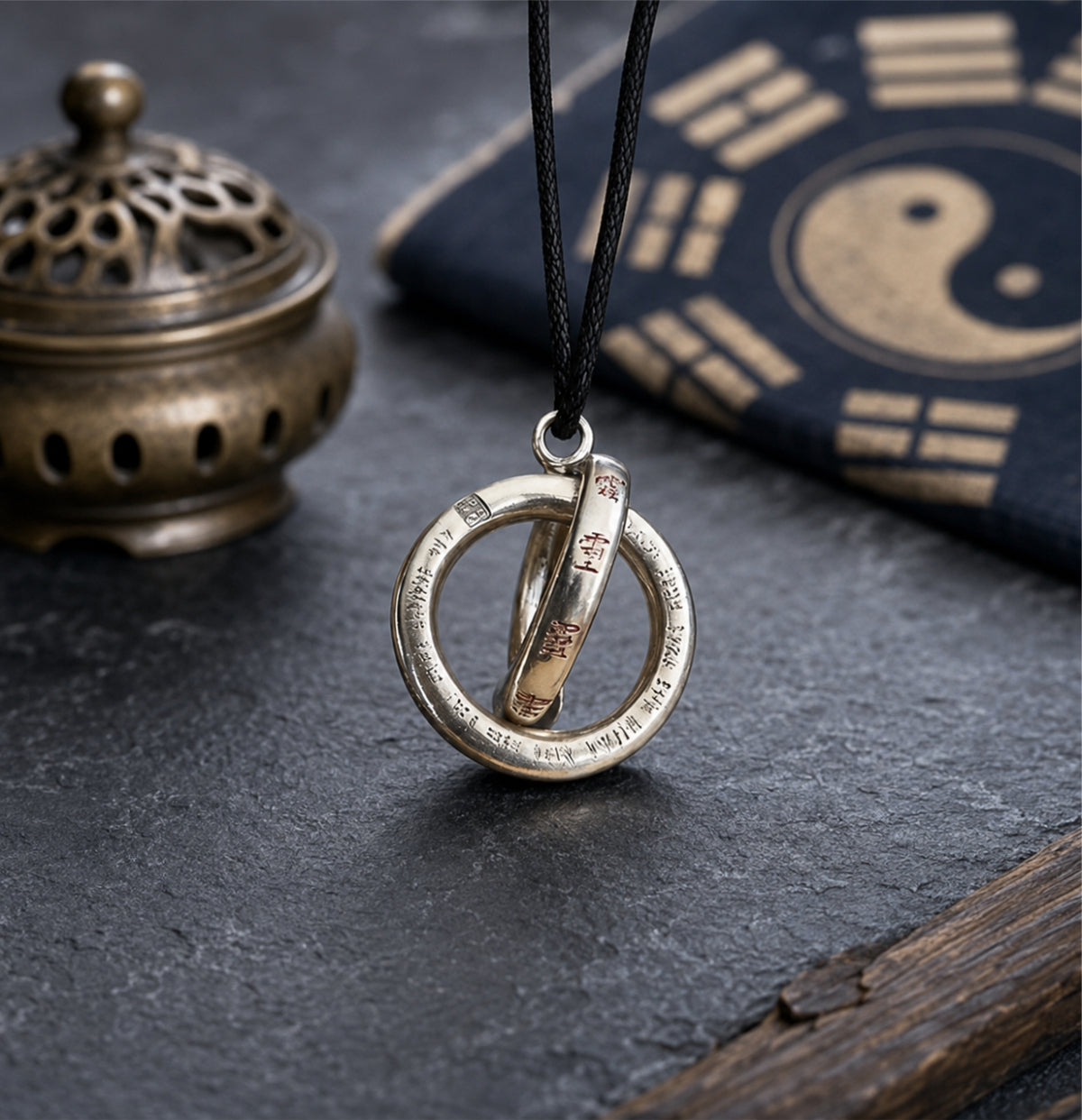 Sterling silver Taoist Yin Yang balance pendant with engraved circular details, displayed beside a Bagua cloth and incense burner.