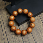 Top view of a thunderstruck wood Five Thunders protection bracelet with gold Taoist talisman engravings