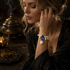 A woman wearing an exquisite Taoist energy protection bracelet with white jade bodhi beads and a blue lotus charm, designed for spiritual grounding and aura defense.