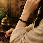 Woman wearing a negative energy protection bracelet in a traditional Taoist-inspired setting