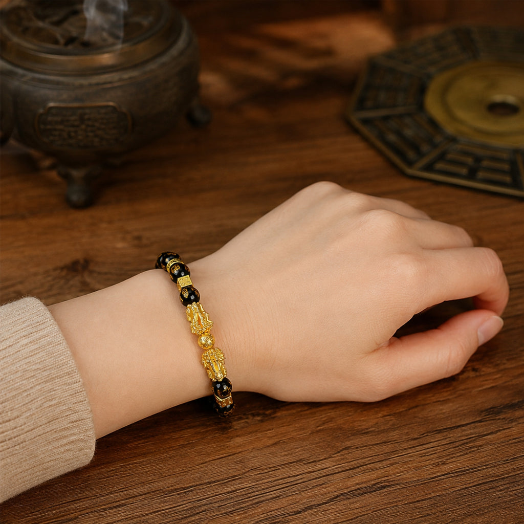 Female wrist wearing a black obsidian double Pixiu wealth attraction bracelet for attracting and retaining wealth.