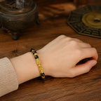 Female wrist wearing a black obsidian double Pixiu wealth attraction bracelet for attracting and retaining wealth.
