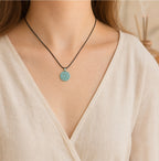 Female wearer with a natural blue-green jade Taoist Shan Gui protection pendant on a black cord.