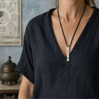 Female model wearing a Taoist supreme protection and fortune talisman necklace with a slim silver pendant.