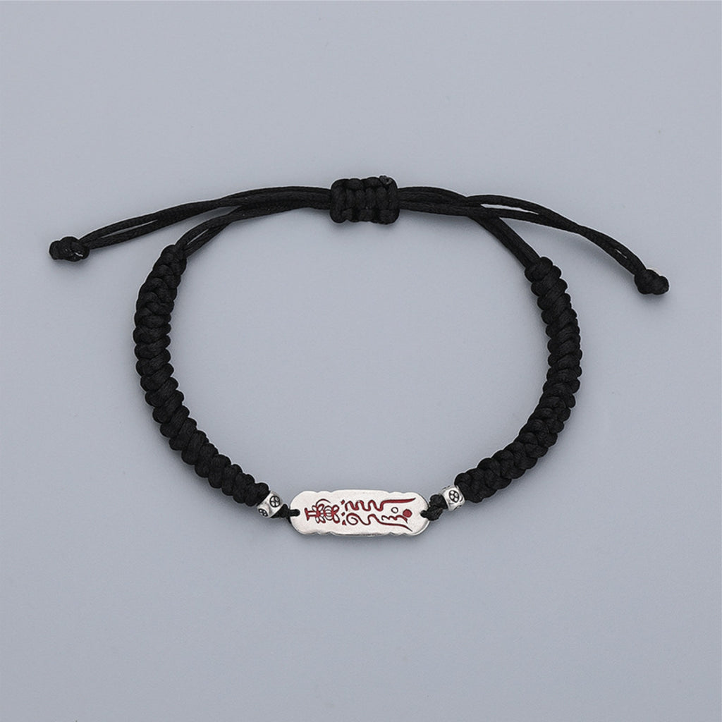 Adjustable black cord bracelet with sliding knot and silver talisman charm, white background