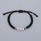 Adjustable black cord bracelet with sliding knot and silver talisman charm, white background