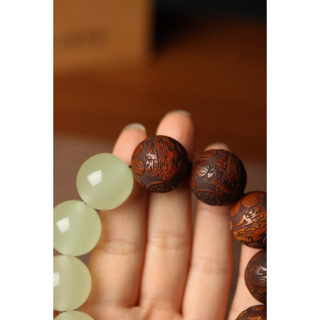 Carved tea quartz wood bead closeup detail on tai chi yin yang meditation bracelet showing intricate Taoist scripture engraving