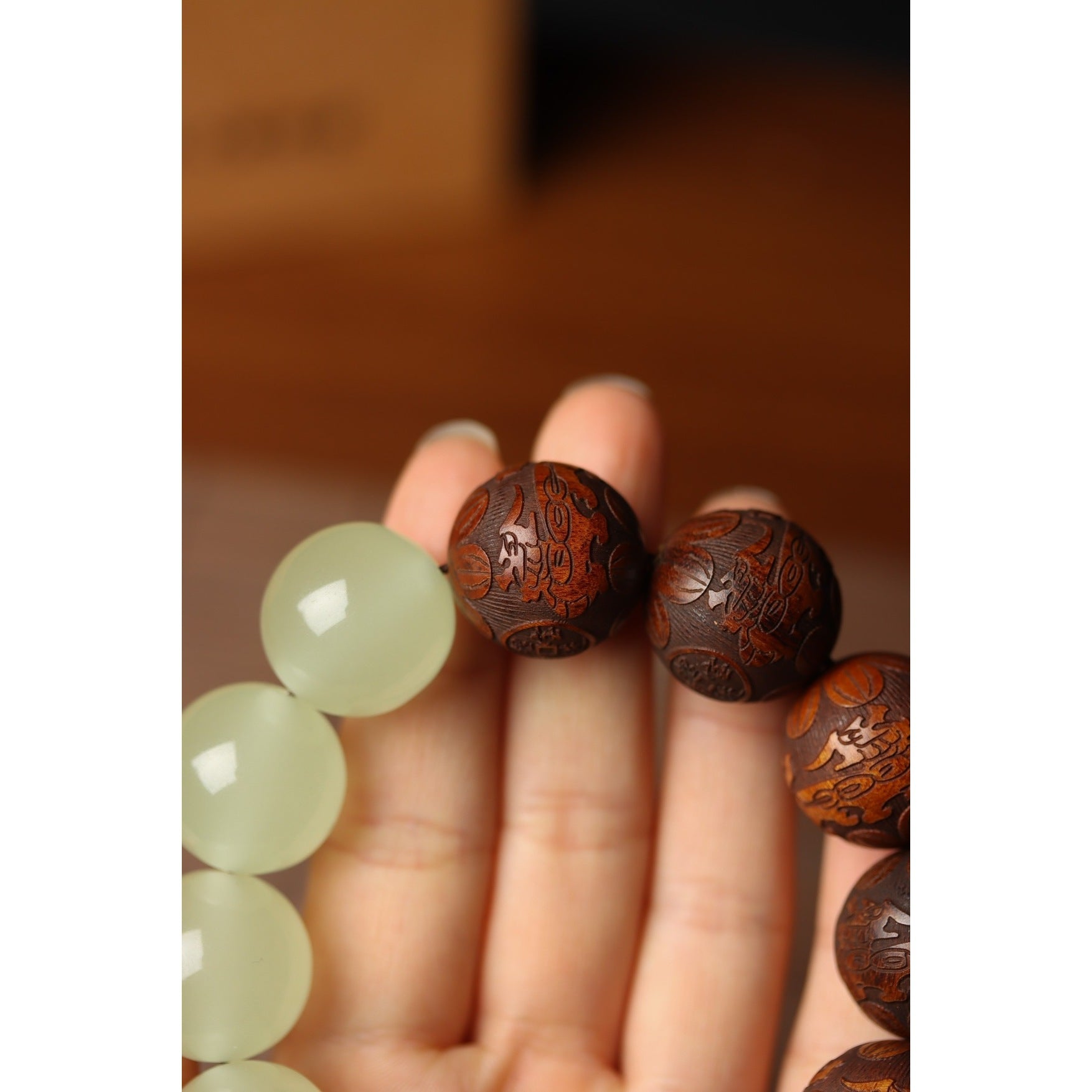 Carved tea quartz wood bead closeup detail on tai chi yin yang meditation bracelet showing intricate Taoist scripture engraving