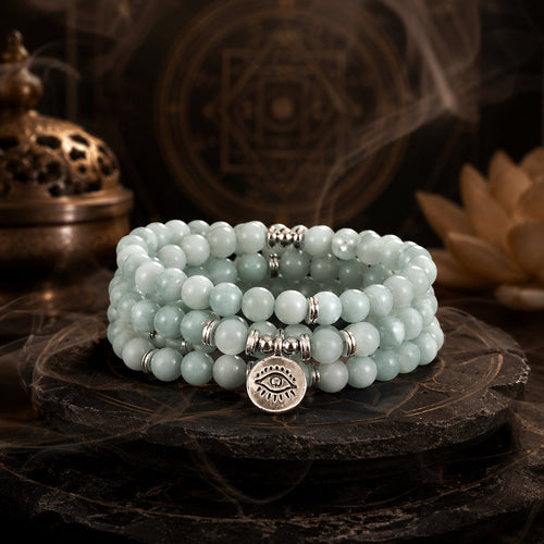 Amazonite 108 bead mala bracelet triple wrap with eye of truth pendant displayed on dark Taoist altar with bronze incense burner and lotus flower meditation anxiety relief