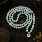 Amazonite 108 bead mala necklace laid flat on black yin yang bagua plate with eye of truth silver pendant Taoist KaiGuang meditation grounding