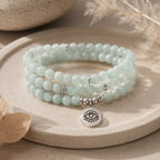 Amazonite 108 bead mala bracelet triple wrap with eye of truth silver pendant on beige ceramic plate natural light pampas grass background meditation gemstone jewelry