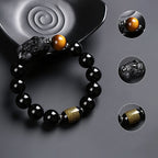 Black obsidian Pixiu bracelet detail showing carved Pixiu guardian tiger eye bead and gold scripture barrel