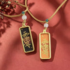 Black and orange Taoist talisman pendants displayed side by side with woven cords and pale round beads.