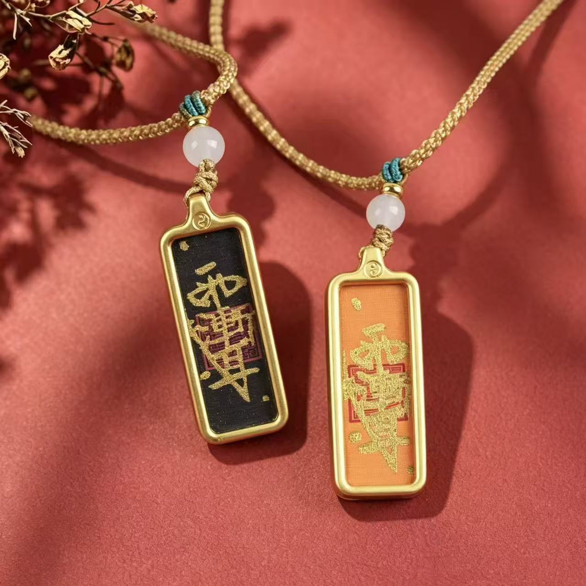 Black and orange Taoist talisman pendants displayed side by side with woven cords and pale round beads.
