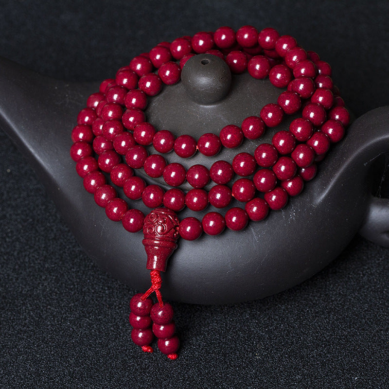108-bead purple cinnabar meditation mala draped on a dark teapot, supreme yang anchor.