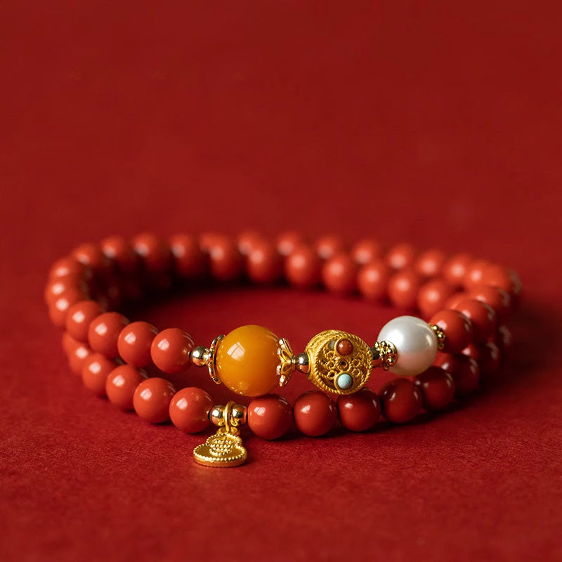 Double layer cinnabar and beeswax bracelet with gold gourd charm resting on red silk — fortune turning jewelry for women