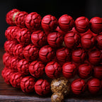 Close-up of hand-carved sacred lotus cinnabar beads showing deep imperial red texture with gold accent spacer bead Taoist consecrated advanced cultivation ritual tool