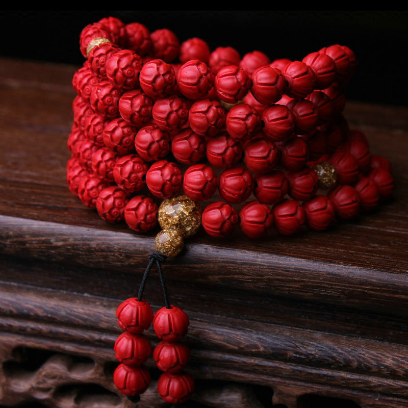 Close-up of lotus-carved cinnabar beads representing spiritual purification and Supreme Yang energy.