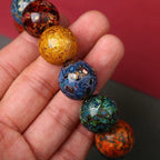 Close-up of colorful handmade lacquer bracelet beads showing gold blue green orange unique texture patterns Taoist KaiGuang artisan energy wealth protection spiritual jewelry