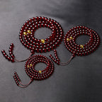 A collection of 108 blood amber mala beads ritualized at Longhu Mountain for life force.