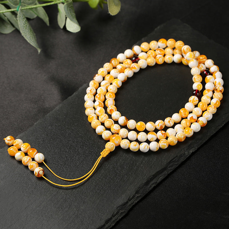 Close-up of natural white flower beeswax beads with official Taoist consecration certificate.