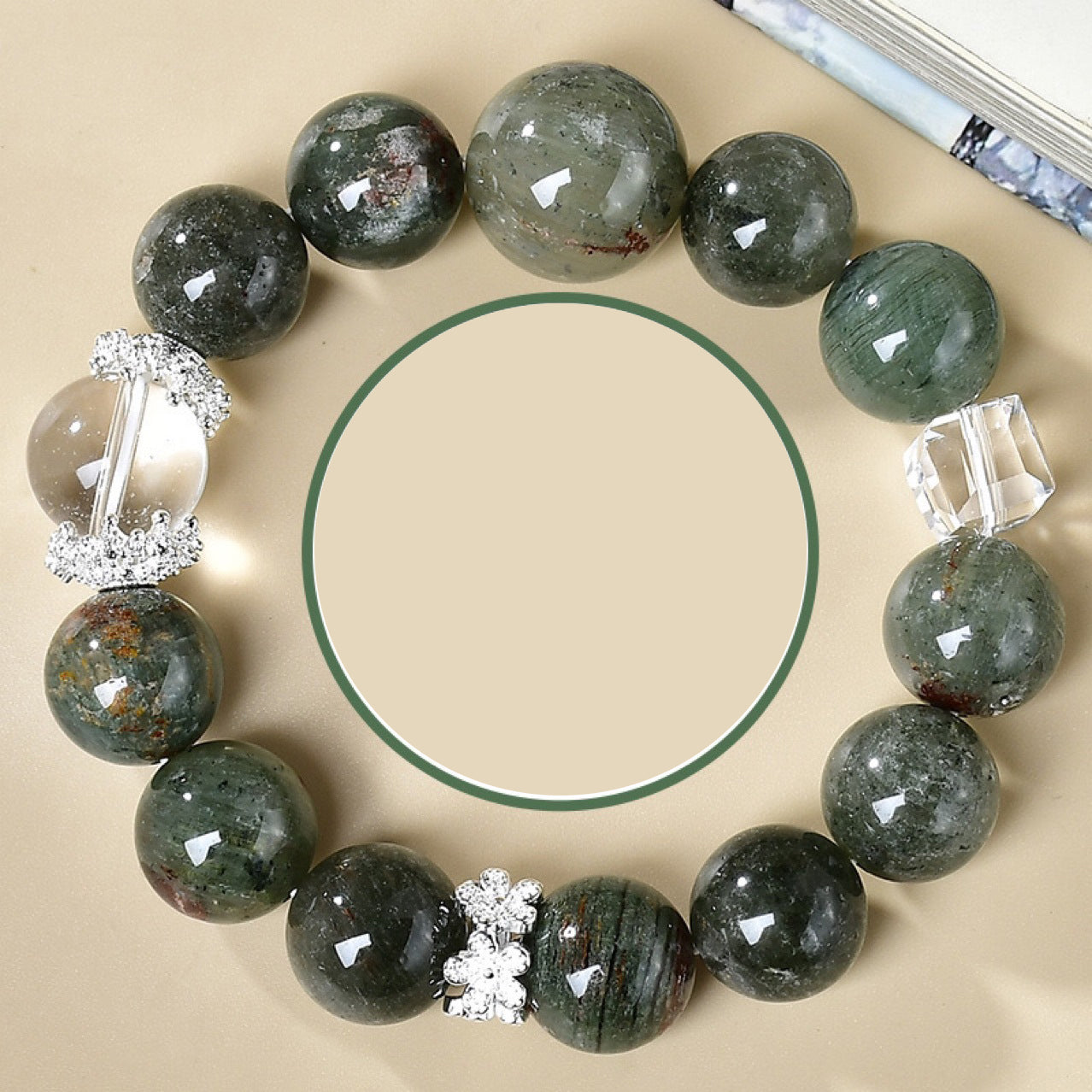 Overhead view green phantom crystal career bracelet with clear quartz cube beads silver flower spacers arranged in circle on cream background Taoist KaiGuang wealth attraction healing